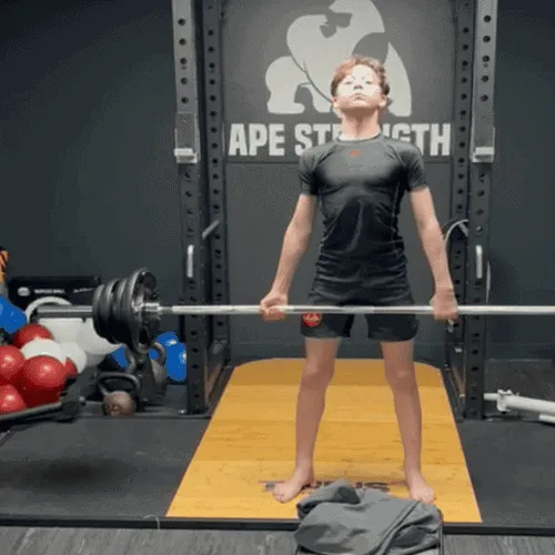 ApeStrength coach assisting an athlete with proper deadlift form during a personal training session.