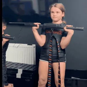 Athlete performing an overhead press with a barbell, showcasing strength training at ApeStrength.